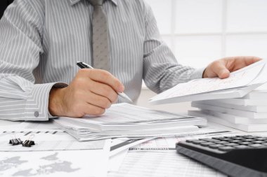 İş dünyası konsepti - iş adamının çalışma masası yakın görünümü, mali raporları kontrol etmesi, yazması ve sayması