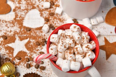 Mutlu noeller ya da yeni yıl dekorasyonu için tatlı yemek arka planı - çikolata şekerlemeleri, mandalinalar, kurabiyeler, marşmelov ve beyaz ahşap üzerine kakao latte