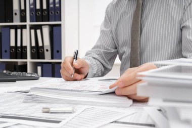 İş dünyası konsepti - iş adamının çalışma masası yakın görünümü, mali raporları kontrol etmesi, yazması ve sayması