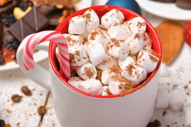 Mutlu noeller ya da yeni yıl dekorasyonu için tatlı yemek arka planı - çikolata şekerlemeleri, mandalinalar, kurabiyeler, marşmelov ve beyaz ahşap üzerine kakao latte