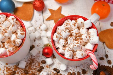 Mutlu noeller ya da yeni yıl dekorasyonu için tatlı yemek arka planı - çikolata şekerlemeleri, mandalinalar, kurabiyeler, marşmelov ve beyaz ahşap üzerine kakao latte