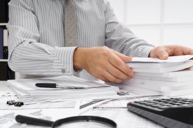 İş dünyası konsepti - iş adamının çalışma masası yakın görünümü, mali raporları kontrol etmesi, yazması ve sayması