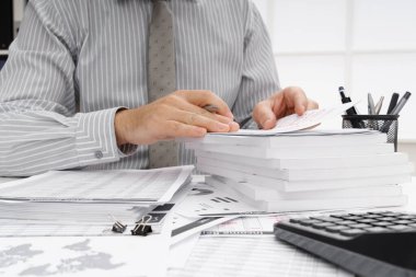 İş dünyası konsepti - iş adamının çalışma masası yakın görünümü, mali raporları kontrol etmesi, yazması ve sayması