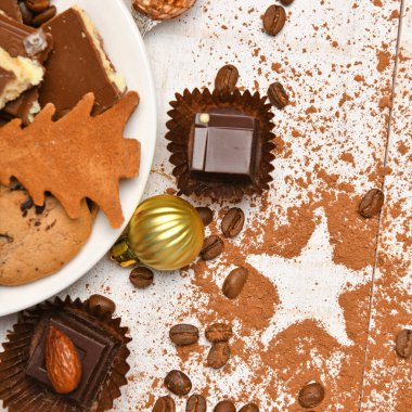 Mutlu noeller ya da yeni yıl dekorasyonu için tatlı yemek üst görünümü - çikolata şekerler, mandalinalar, beyaz ahşap üzerinde kurabiyeler