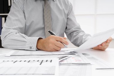 İş dünyası konsepti - iş adamının çalışma masası yakın görünümü, mali raporları kontrol etmesi, yazması ve sayması