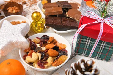 Mutlu noeller ya da yeni yıl dekorasyonu için tatlı yemek üst görünümü - çikolata şekerler, mandalinalar, beyaz ahşap üzerinde kurabiyeler