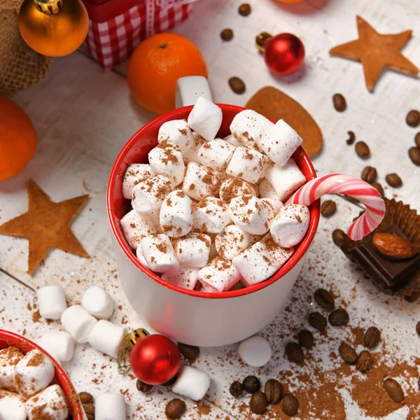 Mutlu noeller ya da yeni yıl dekorasyonu için tatlı yemek arka planı - çikolata şekerlemeleri, mandalinalar, kurabiyeler, marşmelov ve beyaz ahşap üzerine kakao latte