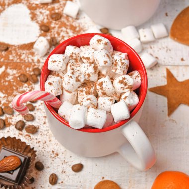 Mutlu noeller ya da yeni yıl dekorasyonu için tatlı yemek arka planı - çikolata şekerlemeleri, mandalinalar, kurabiyeler, marşmelov ve beyaz ahşap üzerine kakao latte