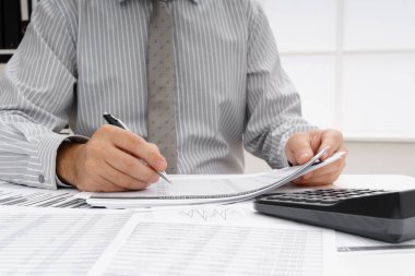 İş dünyası konsepti - iş adamının çalışma masası yakın görünümü, mali raporları kontrol etmesi, yazması ve sayması