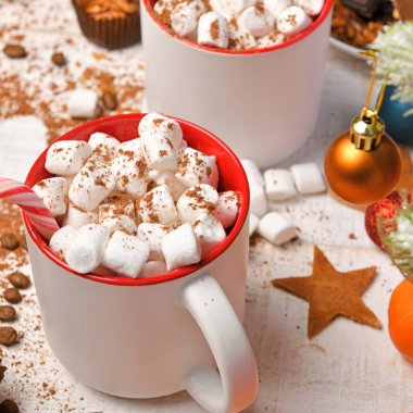 Mutlu noeller ya da yeni yıl dekorasyonu için tatlı yemek arka planı - çikolata şekerlemeleri, mandalinalar, kurabiyeler, marşmelov ve beyaz ahşap üzerine kakao latte