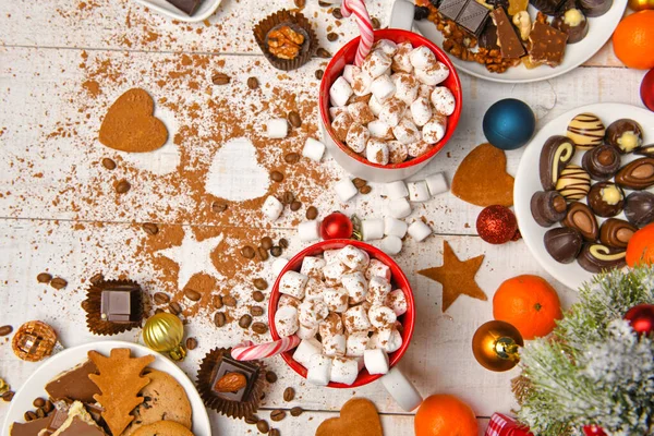 甘い食べ物のトップビューの背景メリークリスマスや新年の休日の装飾 白い木の上にチョコレートキャンディー みかん クッキー マシュマロとココアラテ — ストック写真