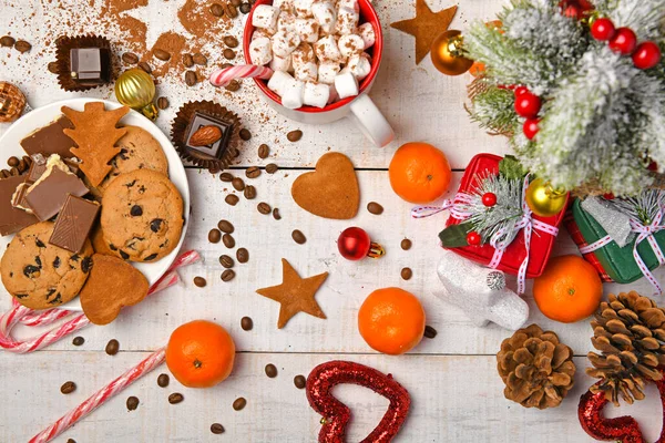 甘い食べ物のトップビューの背景メリークリスマスや新年の休日の装飾 白い木の上にチョコレートキャンディー みかん クッキー マシュマロとココアラテ — ストック写真