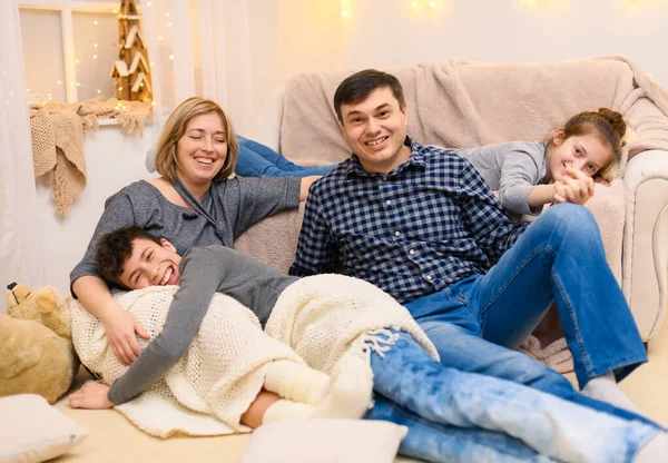 一个家庭坐在沙发上的画像 四个人在一起玩乐 — 图库照片