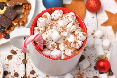 Mutlu noeller ya da yeni yıl dekorasyonu için tatlı yemek arka planı - çikolata şekerlemeleri, mandalinalar, kurabiyeler, marşmelov ve beyaz ahşap üzerine kakao latte