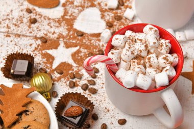 Mutlu noeller ya da yeni yıl dekorasyonu için tatlı yemek arka planı - çikolata şekerlemeleri, mandalinalar, kurabiyeler, marşmelov ve beyaz ahşap üzerine kakao latte