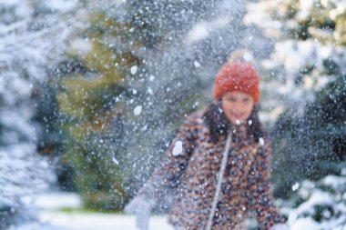 Çocuk kar kusar ve kış ormanlarında oynar, parlak karlı köknar ağaçları, güzel doğa.