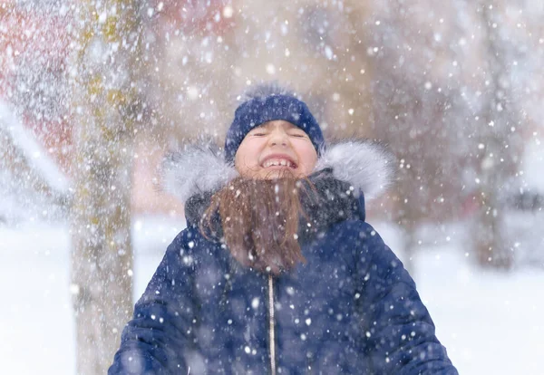 child girl playing with snow in winter outdoor and having fun on snowy winter