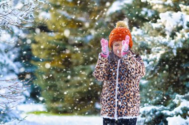 Çocuk kar kusar ve kış ormanlarında oynar, parlak karlı köknar ağaçları, güzel doğa.