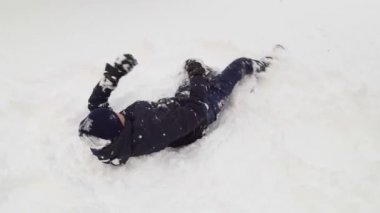 Genç çocuk kışın açık havada karla oynuyor.