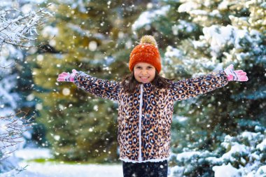 Çocuk kar kusar ve kış ormanlarında oynar, parlak karlı köknar ağaçları, güzel doğa.