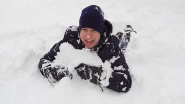 Adam kışın açık havada karda oynuyor ve bocalayıp duruyor.