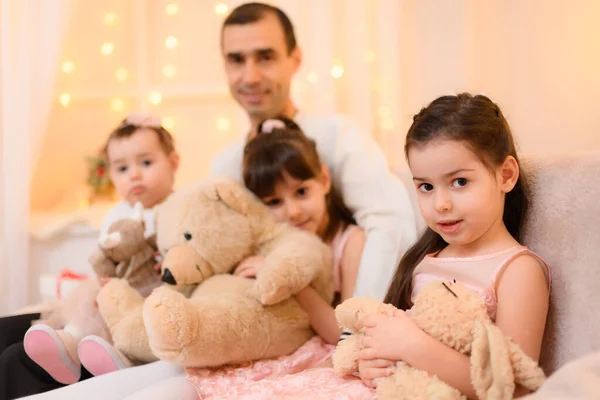 一个父亲和孩子的全家福 坐在家里的沙发上 用彩灯装饰 — 图库照片