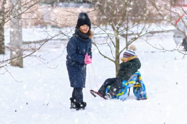 Çocuklar kışın açık havada oynarlar ve kızak sürerler. Karlı kışta eğlenirler.