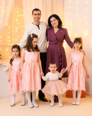 Aile portresi ev içi aydınlatma ve bayram hediyeleriyle dekore edilmiş.