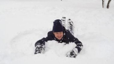 Adam kışın açık havada karda oynuyor ve bocalayıp duruyor.