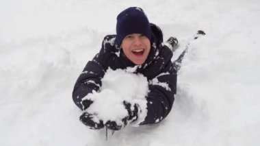 Adam kışın açık havada karda oynuyor ve bocalayıp duruyor.