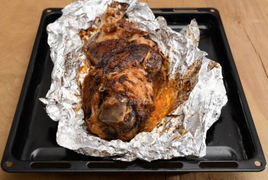 Fırında et ve kızarmış soğan, folyoda domuz eti ve ahşap arka plan, ev yemeği.