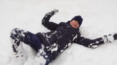 Adam kışın açık havada karda oynuyor ve bocalayıp duruyor.