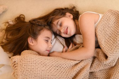 Kızlar yerde yatar, konuşur ya da uyur ve üzerlerini battaniyeyle örterler. Evin içi Noel ışıkları ve hediyelerle süslenir.