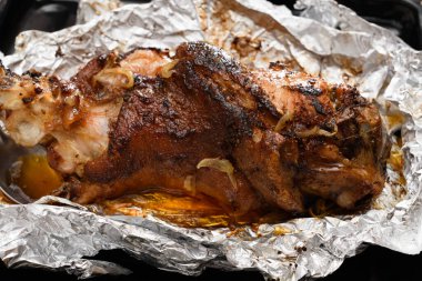 Fırında et ve kızarmış soğan, folyoda domuz eti ve ahşap arka plan, ev yemeği.