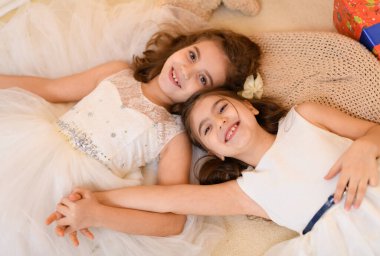 Kızlar yerde yatar, konuşur ya da uyur ve üzerlerini battaniyeyle örterler. Evin içi Noel ışıkları ve hediyelerle süslenir.