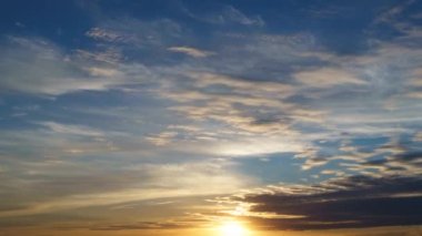 Güzel gün batımı gökyüzü zaman akıp gidiyor. Parlak güneş arka planda kalıyor.