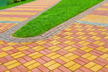 zemin olarak kaldırım taşları ve yeşil çimlerden yapılmış yürüyüş yolu, parlak güneş ışığı
