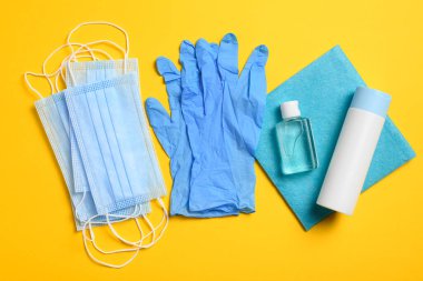 Sarı arka planda virüslere, mikroplara, kovid veya koronavirüse ve diğer enfeksiyonlara karşı solunum koruması için tıbbi maske ve eldivenler