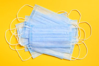 Sarı arka planda virüslere, mikroplara, morina ya da koronavirüse karşı solunum koruma maskesi ve diğer enfeksiyonlara karşı