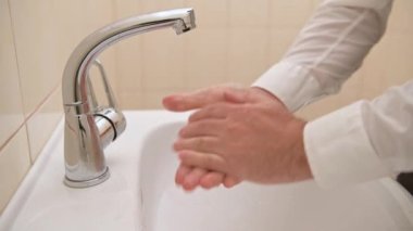 Yıkanırken sabun ya da jöle, lavaboda akan su, temizlik ve hijyen, beyaz gömlek giymiş erkek elleri.