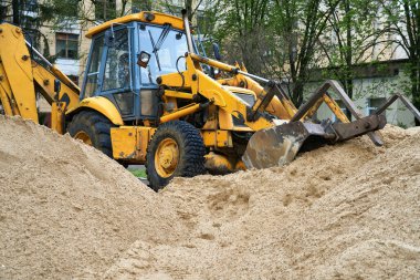 Traktör veya buldozer inşaat için kum yığınıyla çalışır.