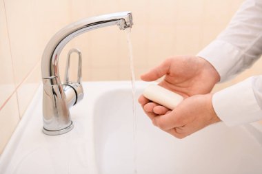 Yıkanırken sabun ya da jöle, lavaboda akan su, temizlik ve hijyen, beyaz gömlek giymiş erkek elleri.