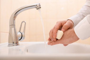 Yıkanırken sabun ya da jöle, lavaboda akan su, temizlik ve hijyen, beyaz gömlek giymiş erkek elleri.