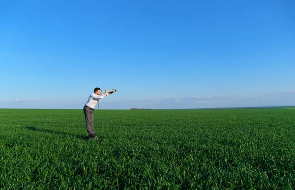 Zakenman Poseert Met Een Verrekijker Een Groen Veld Hij Ziet — Stockfoto