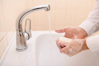 Yıkanırken sabun ya da jöle, lavaboda akan su, temizlik ve hijyen, beyaz gömlek giymiş erkek elleri.