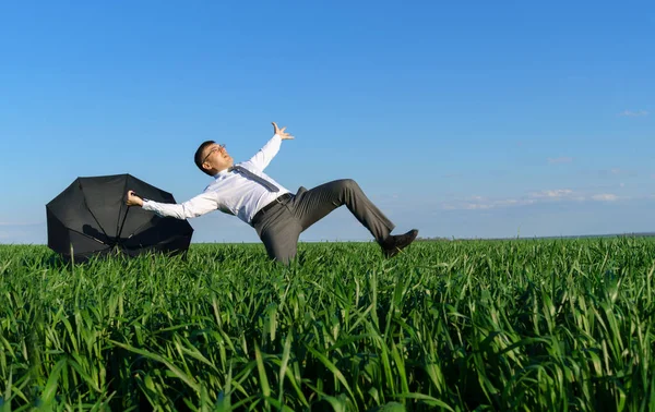 Geschäftsmann Posiert Mit Regenschirm Auf Einem Feld Fällt Ein Krisenbegriff — Stockfoto