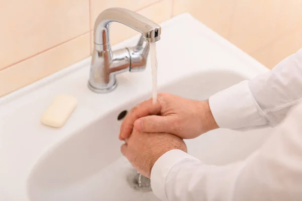 洗面台の水の下で石鹸やゲルで手を洗う 清潔と衛生 白いシャツを着た男性の手 — ストック写真
