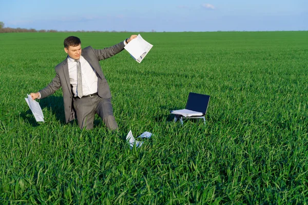 businessman works in a green field, freelance and business concept, green grass and blue sky as background