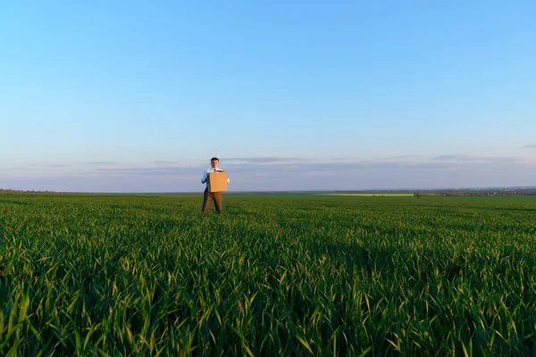 Uomo Affari Tiene Una Scatola Cartone Posa Campo Erba Verde — Foto Stock