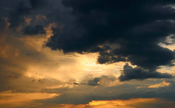 背景には美しい夕焼け空明るい太陽と暗い雲のシルエット — ストック写真